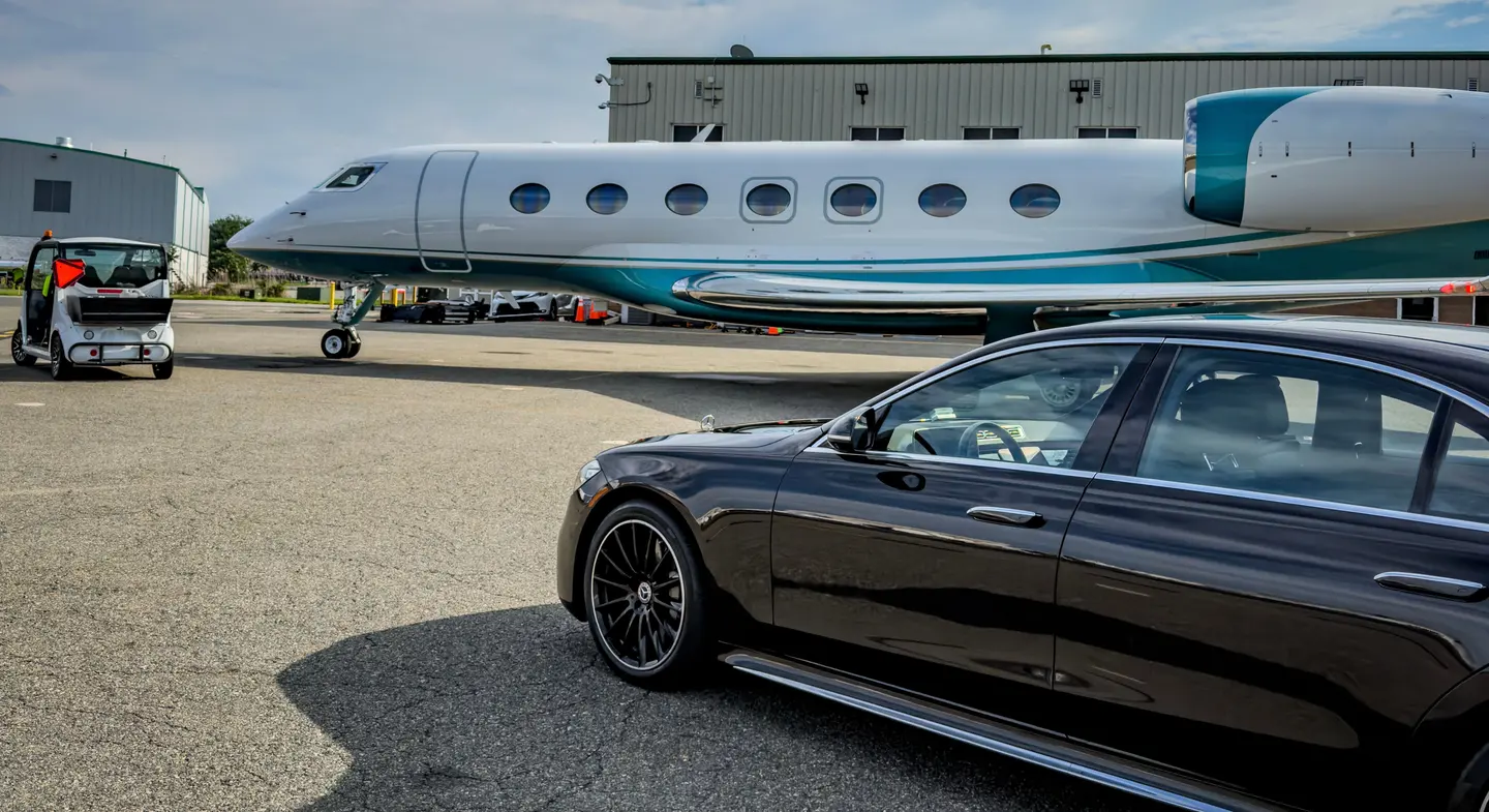 DV Executive Mercedes-Benz S-Class staged beside a Gulfstream private jet on an FBO ramp